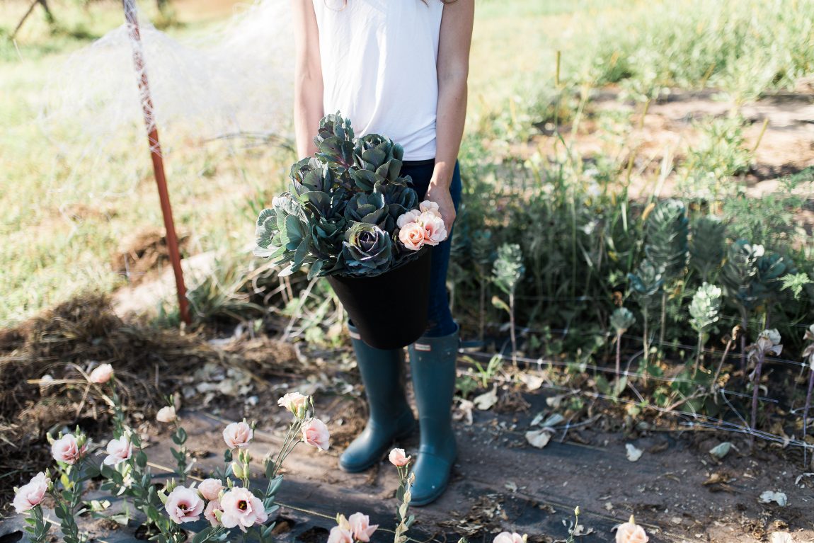 woman with bucket of flowers in field
